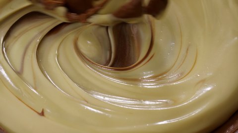 Mixing hazelnut chocolate cream. Mixing melted liquid milk chocolate with a whisk.