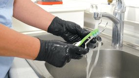 Tools sterilization, bacterial purification and disinfection in dental clinic. Dental clinic assistant washing dentist tools with brush under running water from faucet. Close-up. 4 k video