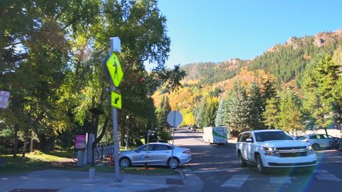 Aspen, USA - October 3, 2019: Car point of view driving on west main street with Paepcke Park in Colorado mountain town city in autumn season