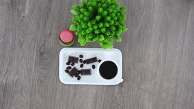 Top view spinning video of coffee cup with candies and flowers.