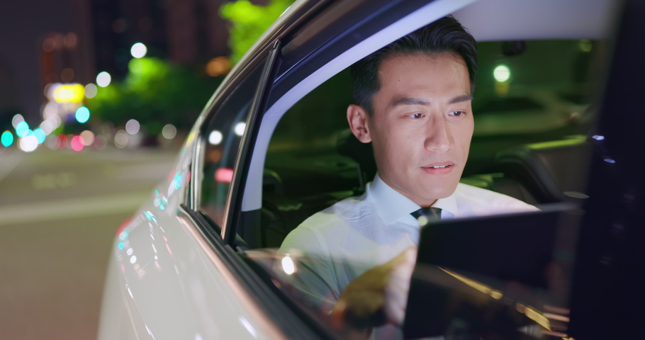 asian businessman uses digital tablet while commuting by taxi at night Royalty-Free Stock Footage #1060070156