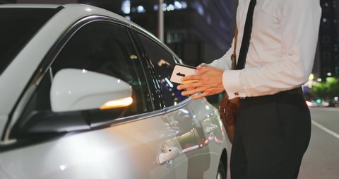 car keyless security concept - asian businessman is unlocking car by using mobile application