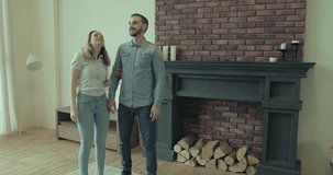 Happy Couple with real-estate agent visiting house for sale or for rent, Young man and woman cheerful at home. Loving people buying an apartment. Immovables market 4K slow motion video.