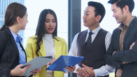 new normal office lifestyle asian businessman and businesswoman casual standing meeting conference together with paper chart and tablet together teamwork achievement concept