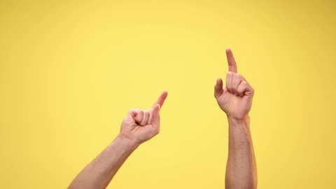 two arms are pointing up, dancing and celebrating succes on yellow background