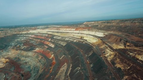 Panorama aerial view shot open pit mine coal mining, dumpers, quarrying extractive industry stripping work. Big Yellow Mining Trucks. View from drone at opencast mining with lots of machinery trucks