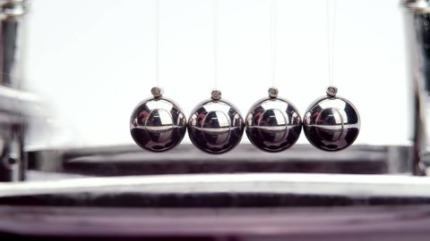 Slow motion shot of Newton's metal balls on white background. Close up.