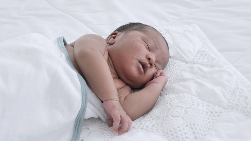 Close up of Mixed race black boy Ethnicity Thai-Nigeria. Newborn baby sleeping on the bed in home and nature sunlight | Shutterstock HD Video #1060094399
