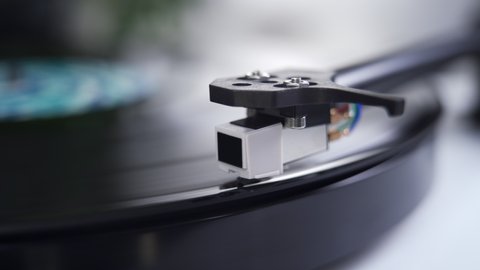 Close up of stylus or needle on turntable with vinyl record spinning