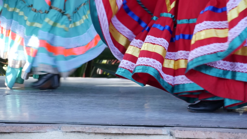 Latino women in colourful traditional dresses dancing Jarabe tapatio, mexican national folk hat dance. Street performance of female hispanic ballet in multi colored ethnic skirts. Girls in costumes. | Shutterstock HD Video #1060095164
