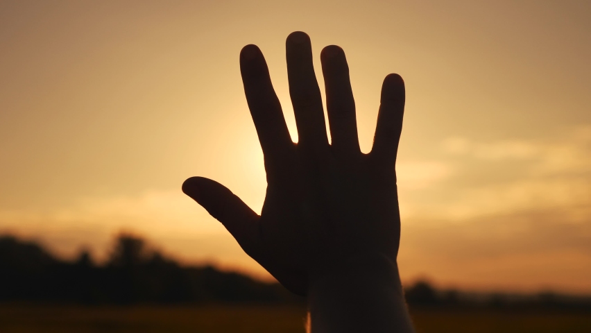 girl stretches out her hand in the sun. faith in god dream a religion concept. hand in the sun close-up silhouette sunlight dream of happiness Royalty-Free Stock Footage #1060095611