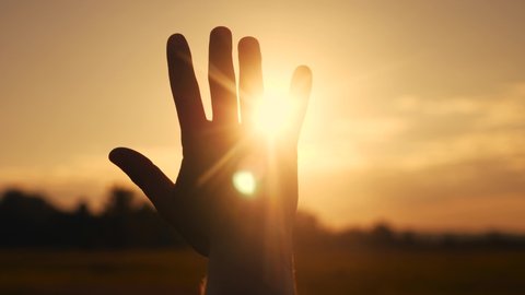 girl stretches out her hand in the sun. faith in god dream a religion concept. hand in the sun close-up silhouette sunlight dream of happiness