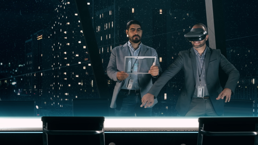 In the Near Future: Professional Designer in Suit wearing AR Headset presenting Architecture Project to Partner standing around Futuristic Table with Holographic Modern Augmented Reality Technology. Royalty-Free Stock Footage #1060102679