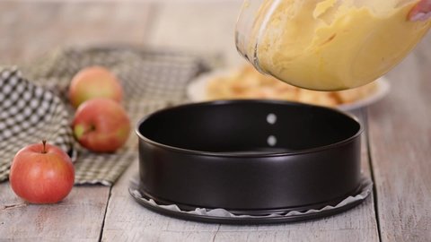 Female Hands Pouring Dough Into Form Baking Apple Pie.