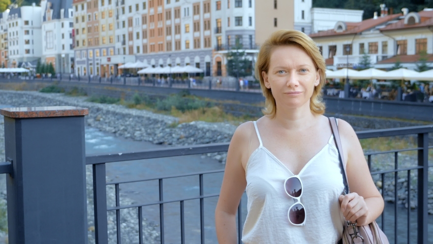 portrait. woman on the bridge against the background of the river. travels.