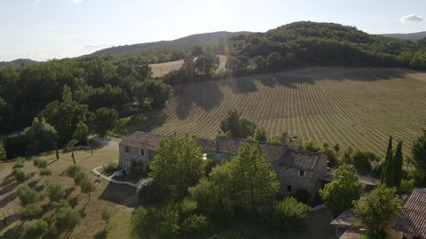 Aerial drone shot of a villa in the countryside of south of France with lavender field rows in the background