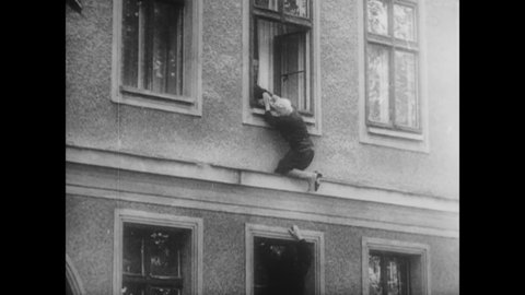 CIRCA 1961 - East Germans struggle out of windows and through barbed wire fences to make it to West Berlin.