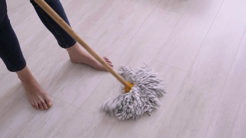 Female housewife washes the floors in the apartment. The mop moves on the floor. Cleaning at home. mop close-up. Routine. wife cleans the house Royalty-Free Stock Footage #1060122599