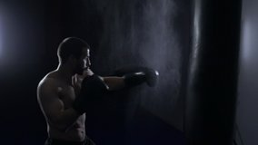 Cinematic slow motion shot of male boxer hitting a punching bag at a boxing studio. Man boxer training hard - Powered by Shutterstock - Get 15% off with code: PIKWIZARD15