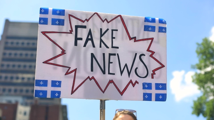 Selective focus of woman hands holding white banner with quebec flag drawings in banner in hand while standing in protest against fake news Royalty-Free Stock Footage #1060123826
