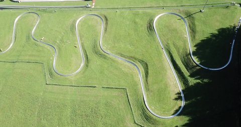 Amazing drone aerial view of a summer bobsleigh track. Passo della Presolana. Bergamo, Italy. Natural contest. Leisure time. Beautiful nature with green meadow. Vertical landscape
