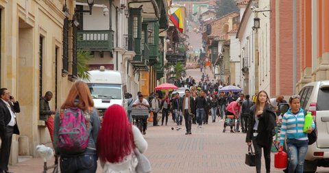 BOGOTA, COLOMBIA - CIRCA 2019: People passing by on a street of La candelaria, historic old town district of Bogota, generic urban view of a busy street