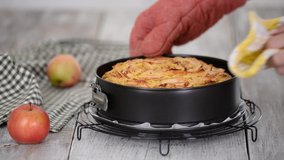 Freshly baked apple cake. Female hands put baked apple pie on cooling rack. - Powered by Shutterstock - Get 15% off with code: PIKWIZARD15