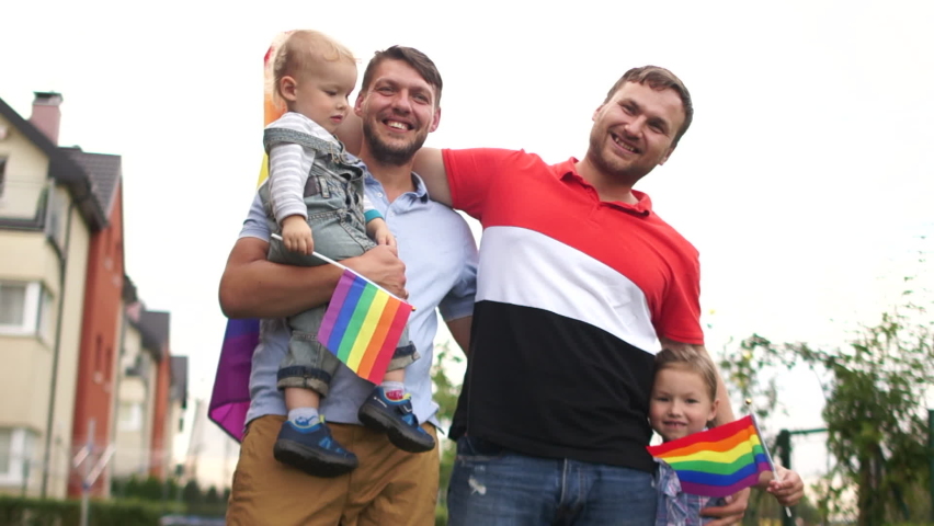 Gay couple. Happy samesex family near their house with flags and two children, a boy and a girl. Gay rights, lgbt community, child adoption, fathers day | Shutterstock HD Video #1060148675