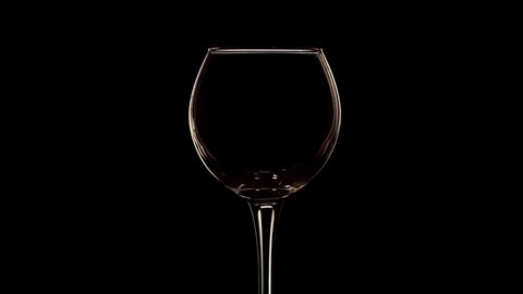Young red wine pouring into wine glass slow motion close up shot