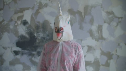 Person in unicorn head mask dancing in slow motion. Funny dancings of unicorn mask.