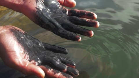 Slick industry oil fuel spilling water pollution. environmental pollution - research. oil in human hands, ecology and environment.