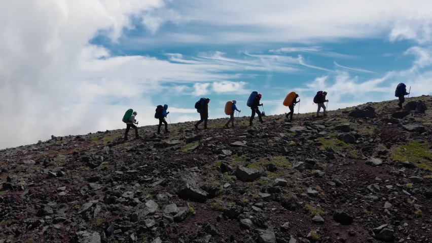 Aerial view of group people hiking along trail path in sunny day. people hikers climbing mountain, team work, travelling, trekking. | Shutterstock HD Video #1060151891