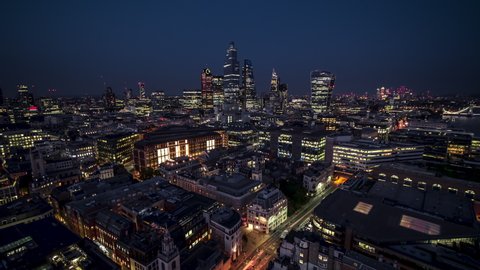 Establishing Aerial View Shot of London UK, beautifully lit City of London Square Mile, London Skyline, United Kingdom at night evening