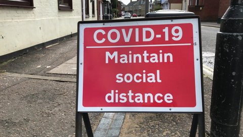 COVID-19 Maintain Social Distance, Road Signage on Public Street in the UK. Filmed October 2020.