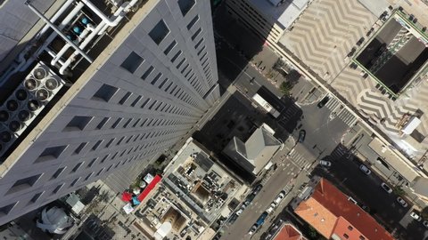 Slow descend to street from a skyscraper in Tel Aviv while traffic moves below