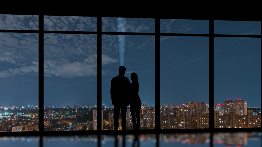 The man and woman stand near the windows on the night city background. time lapse Royalty-Free Stock Footage #1060177271