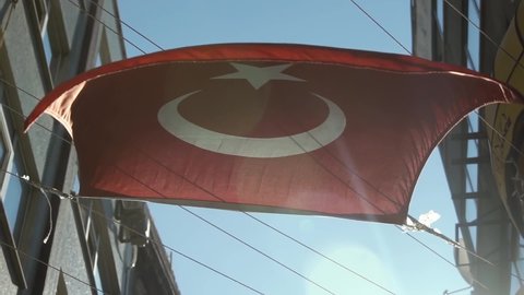 Turkish flag waving on a street of Istanbul against sunlight. National symbol of Turkey. Slow motion