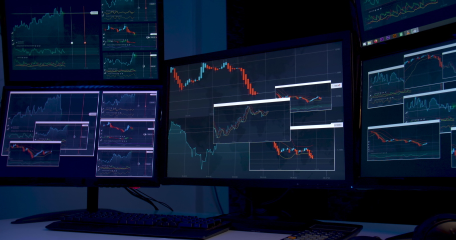 Asian business man is sitting at desk with monitors showing line graphs, charts. Alone male is analyzing stock market trading, strategic planning project of marketing data at late night. Dolly shot. Royalty-Free Stock Footage #1060187531