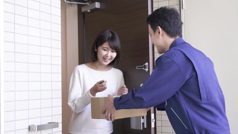 Young woman receives parcel from courier