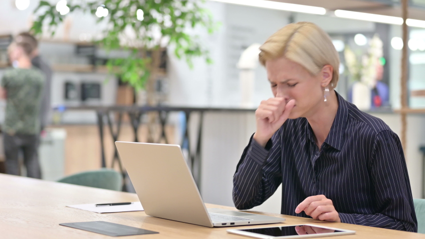 Sick Young Businesswoman with Laptop Coughing in Office  | Shutterstock HD Video #1060190258