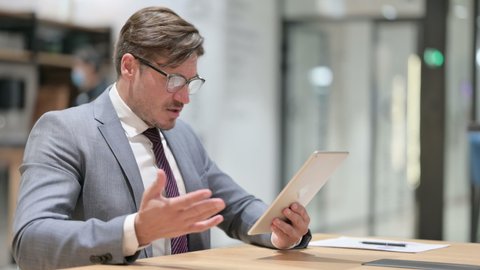 Disappointed Businessman having Loss on Tablet in Office