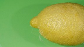 Lemon close-up. Green background. Citrus fruit. Yellow textured fruit.