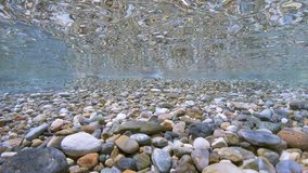 Pebbles rocks underwater below water surface on the shore, Mediterranean sea, natural scene, France
