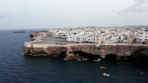 Aerial view of the spring cityscape of Polignano a Mare town, Puglia region, Italy, Europe. Superb view of Adriatic sea. Traveling concept background. Turquoise sea water with many yachts.