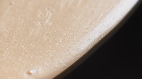 Cosmetic Silky Beige Cream Flowing Down On A Black Surface. - macro shot - slow motion : vidéo de stock