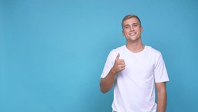 Young caucasian man smiling and raising thumb up