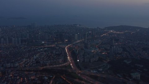 Wide Aerial View over Istanbul New Financial District at Dusk with Freeway traffic, tilt down