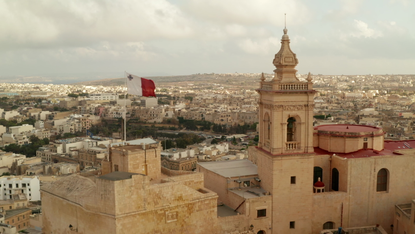 Beautiful Gozo Sand Castle Fort with Malta Flag waving revealing Countryside of Gozo Island, Aerial forward dolly Royalty-Free Stock Footage #1060212386