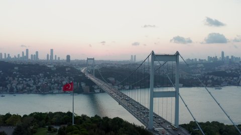 Istanbul 15 July Martyrs Bosphorus Bridge and City Skyline in Background with Turkish Flag at Beautiful Sunset, Aerial slide right