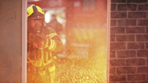 Fireman extinguish fire with the hose. Burning house fire drill. High quality 4k footage